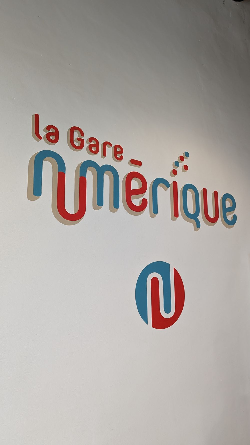 Le logo de la Gare Numérique peint sur le mur à l'entrée du bâtiment (intérieur)